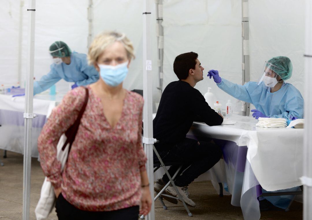 Una sanitaria le realiza un frotis nasal a un vecino de Ordizia en una de las carpas instaladas en el parque Barrena por el Ayuntamiento de Ordizia para realizar test ante el posible brote de COVID-19 detectado en la localidad guipuzcoana, en Ordizia,