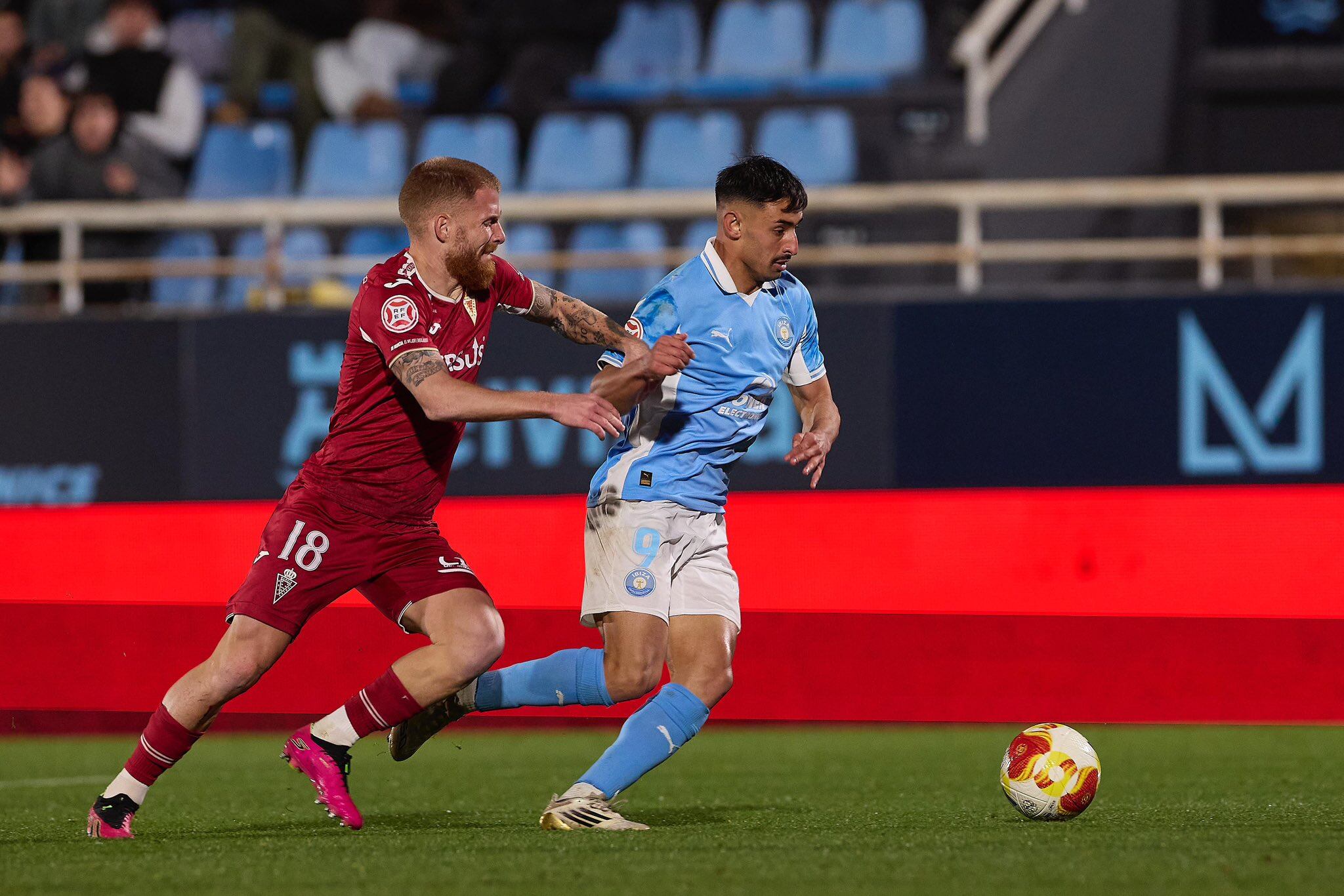Davo, jugador de la UD Ibiza, pugna un balón con David Vicente, jugador del Real Murcia.