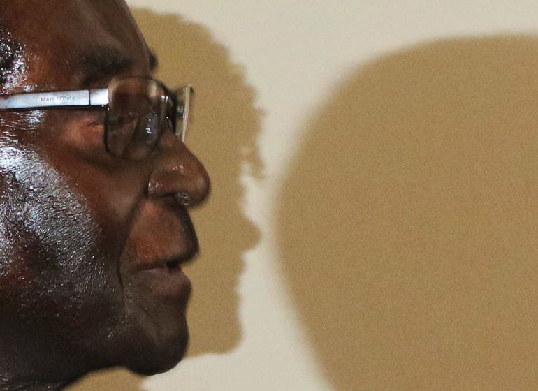  Robert Mugabe, que hoy cumple 93 años, en esta fotografia reciente con la sombra del perfil de su mujer Grace de fondo. Según expertos político, ella se estaría posicionando para sucederle en el cargo. 