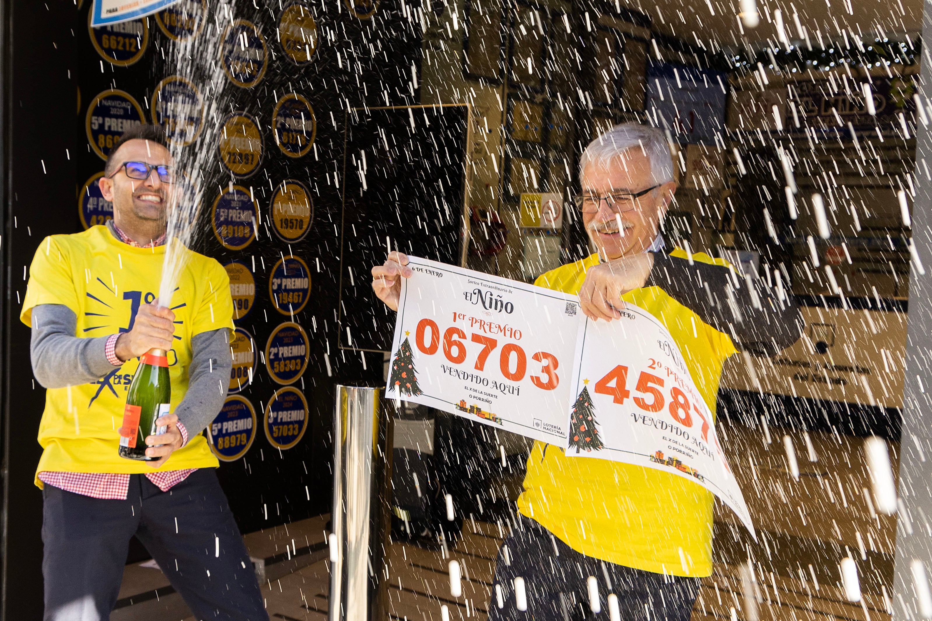 O Porriño (Pontevedra) 06/01/2026.- Andrés y benjamín Martinez, propietarios de la administración de Loterías de O Porriño, celebran haber repartido parte del segundo premio y un décimo del primero en el sorteo del Niño. EFE / Salvador Sas