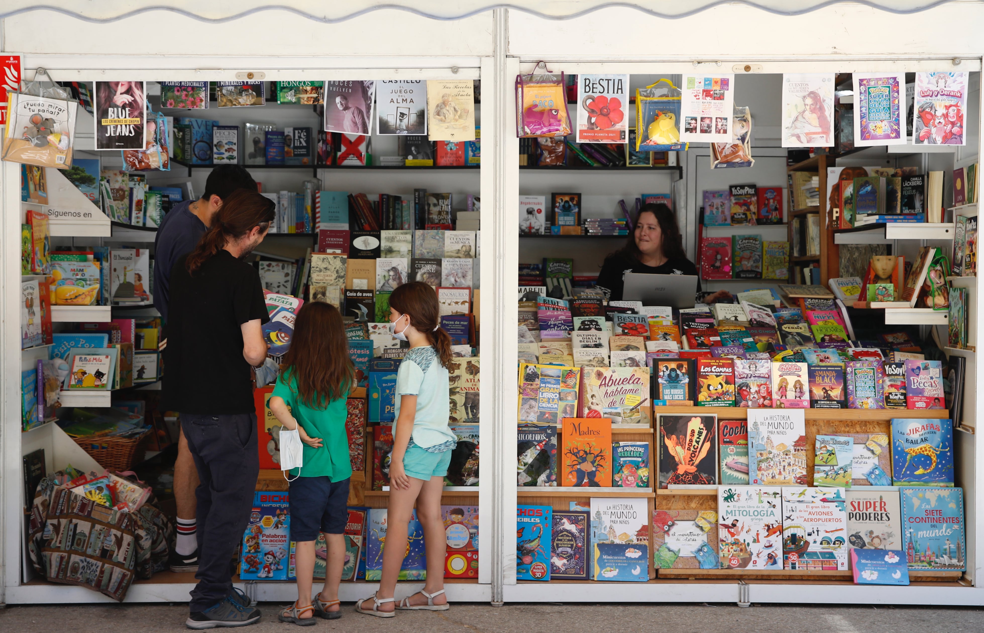 Dos niñas eligen libros en una de las casetas de la Feria del Libro de Madrid. EFE/Javier López