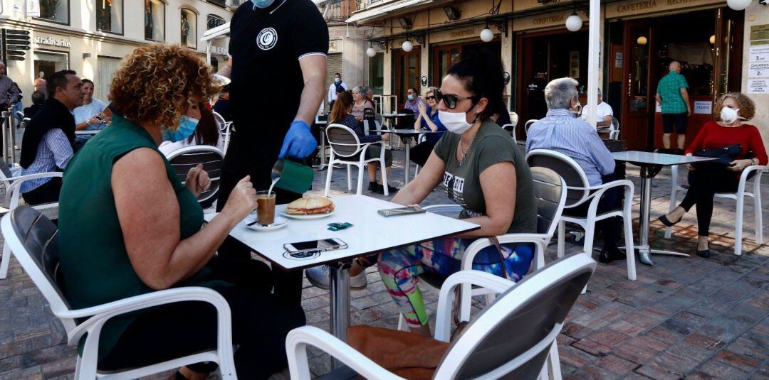 Un camarero atiende en una terraza.