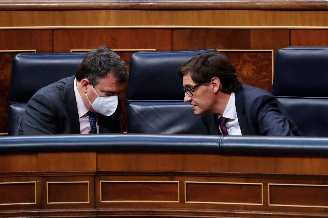 El portavoz del PNV, Aitor Esteban (i), conversa con el ministro de Sanidad, Salvador Illa (d), durante el del pleno del Congreso que debate este miércoles la quinta prórroga del estado de alarma después de que el Gobierno rectificara ante la presión de los grupos y solicitara una ampliación de quince días y no de un mes como había planteado en un principio. 