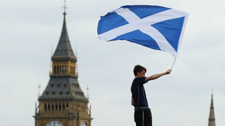 Un joven agitando una bandera de Escocia (Imagen de archivo) 