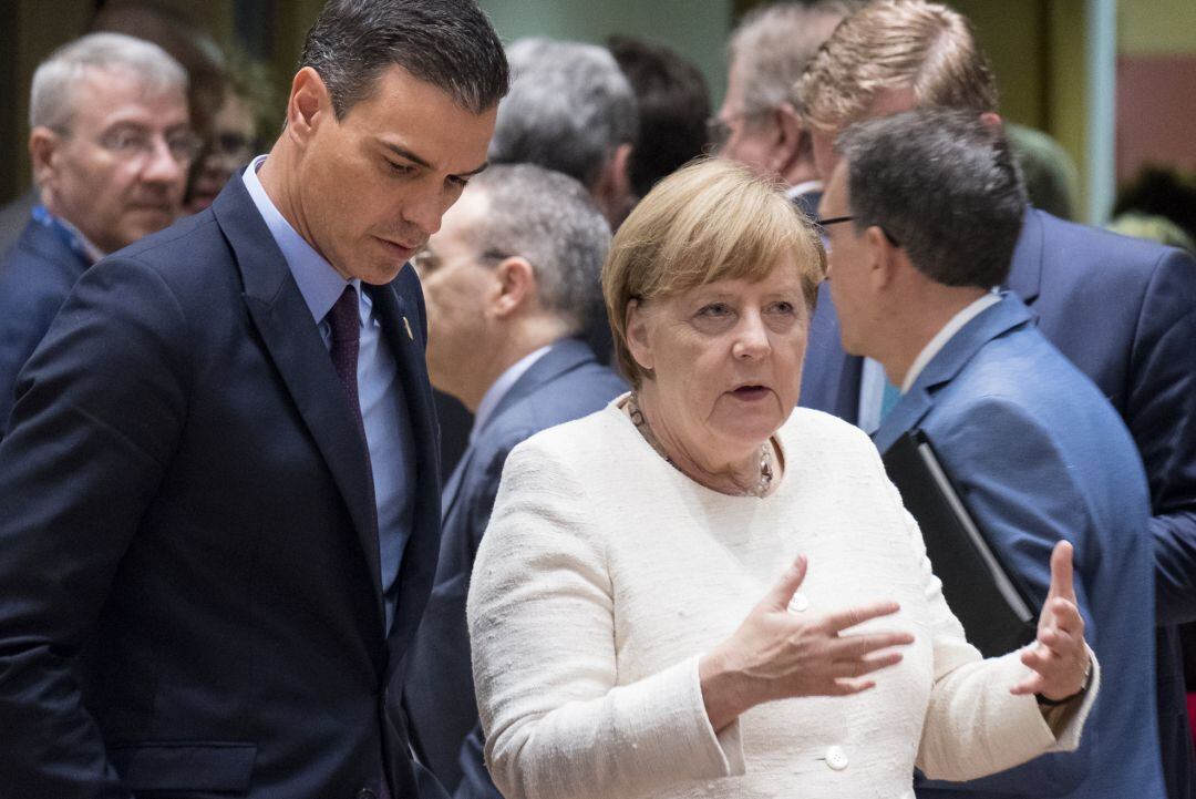 El presidente del Gobierno, Pedro Sánchez, charla con la canciller alemana, angela Merkel, durante el Consejo europeo de este jueves en Bruselas.