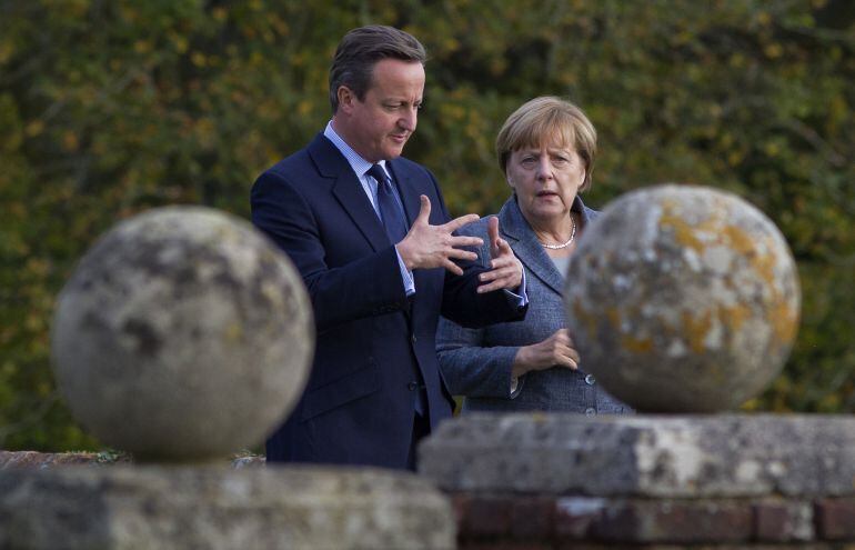 AYLESBURY, UNITED KINGDOM - OCTOBER 9: British Prime Minister David Cameron walks around the rose garden with German Chancellor Angela Merkel (R) during a meeting at Chequers, the Prime Minister&#039;s country residence on October 9, 2015 near Aylesbury, Bucki