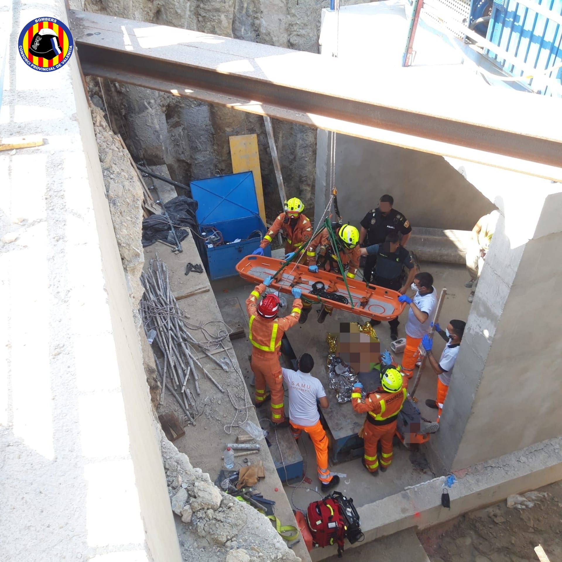 Bomberos y una unidad del SAMU asisten al hombre herido en el sótano de las obras de la estación del tren de Tavernes.