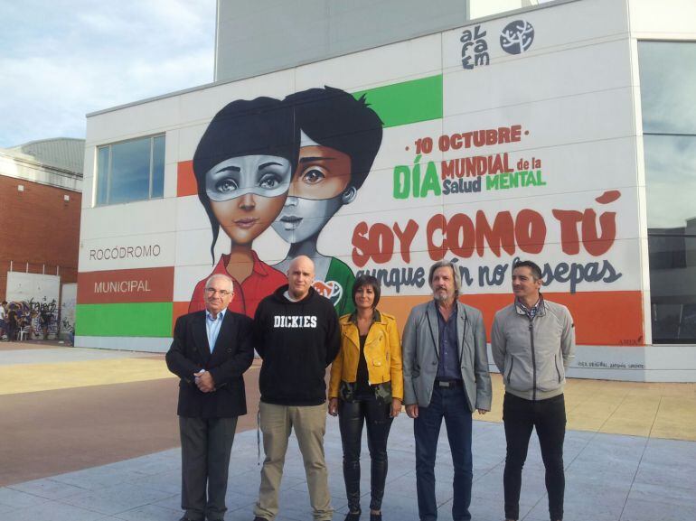 Miembros de ALFAEM y el creador del mural junto a los representantes municipales