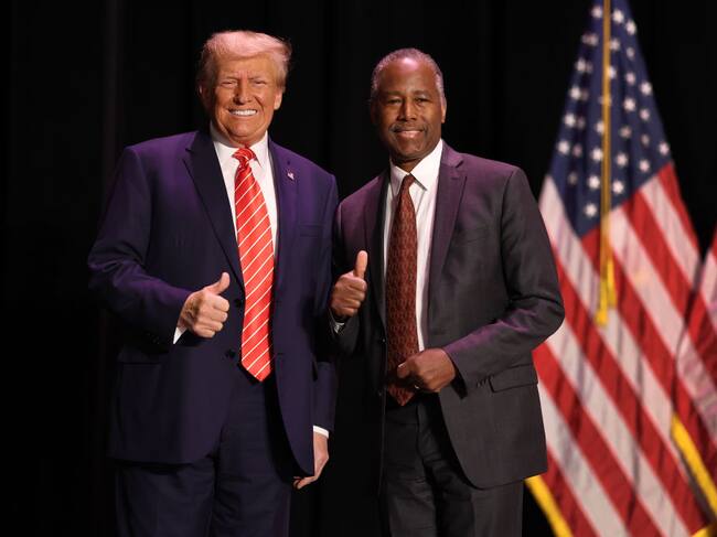 Ben Carson y Donald Trump posan juntos durante un acto público.