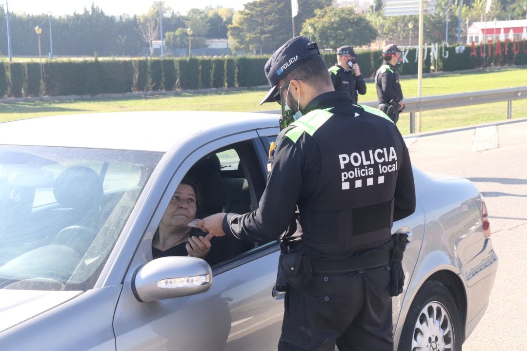 Un policia local de Torredembarra conversant amb una conductora durant el control policial entre municipis. 