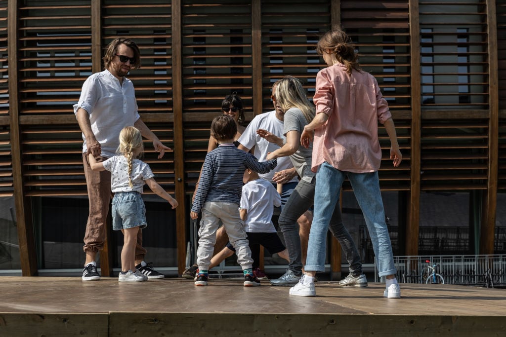 Un padre juega con sus hijos y otros padres en un parque