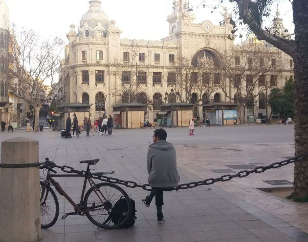 Persona sentada en la plaza del Ayuntamiento de València