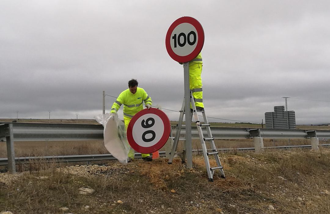 Trabajadores de la Unidad de Carreteras cambian la última señal de la modificación de la velocidad en vías convencionales