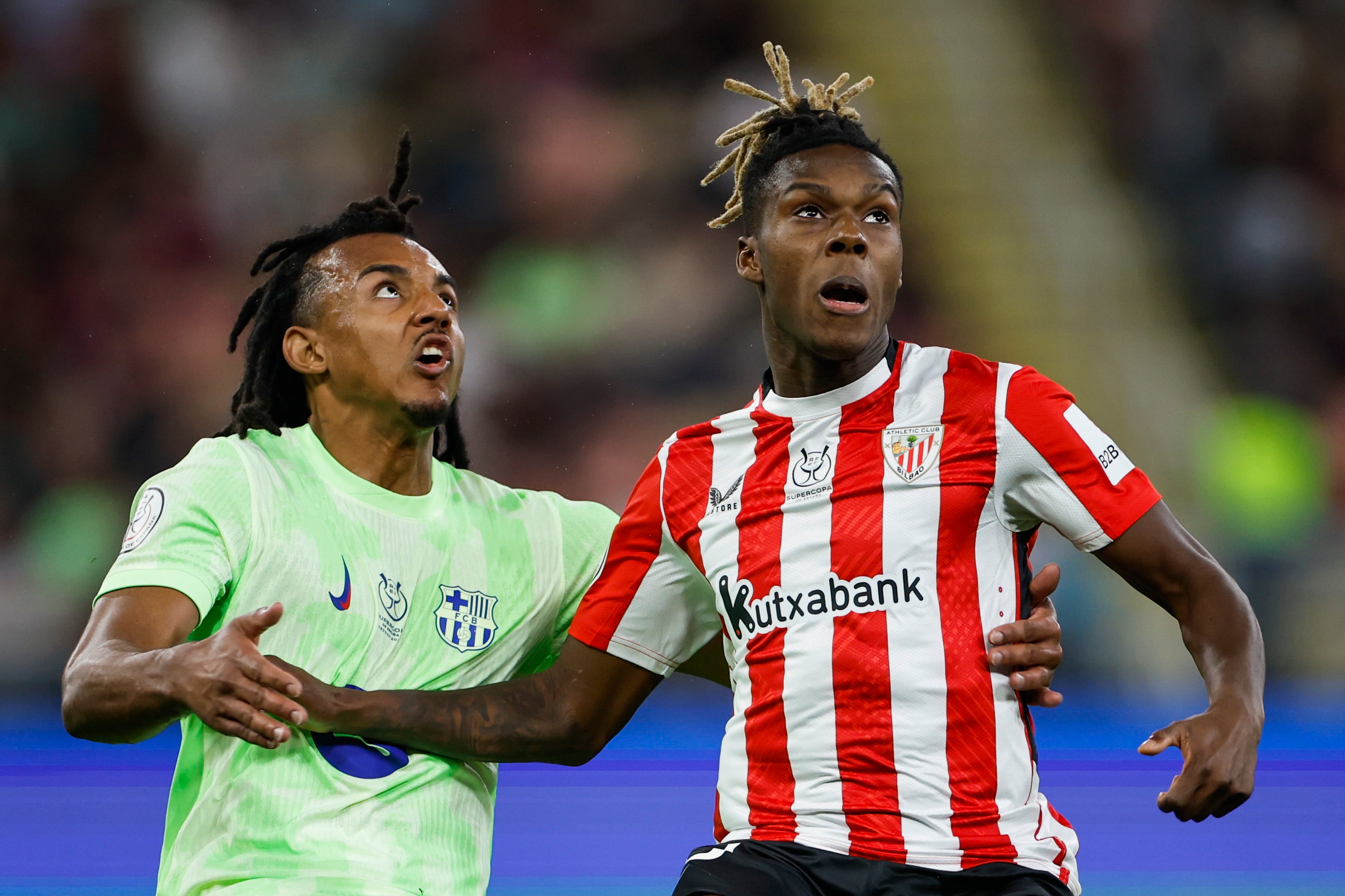 El defensa francés del FC Barcelona, Jules Koundé y el delantero del Athletic Club, Nico Williams, durante el encuentro de semifinales de la Supercopa de España de fútbol que enfrenta este miércoles al FC Barcelona y al Athletic de Bilbao en el estadio Rey Abdullah de Yeda (Arabia Saudí)