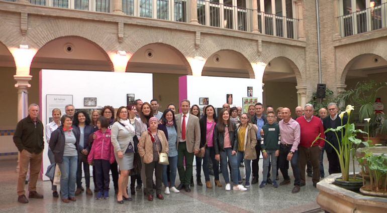 La corporación municipal junto a los asistentes a la inauguracion del al exposición Mi Héroe en el patio del ayuntamiento de Cazorla