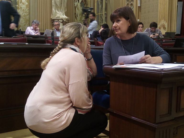 La presidenta del Govern, Francina Armengol, hablando con la consellera de Salud, Patricia Gómez, en el Parlament.