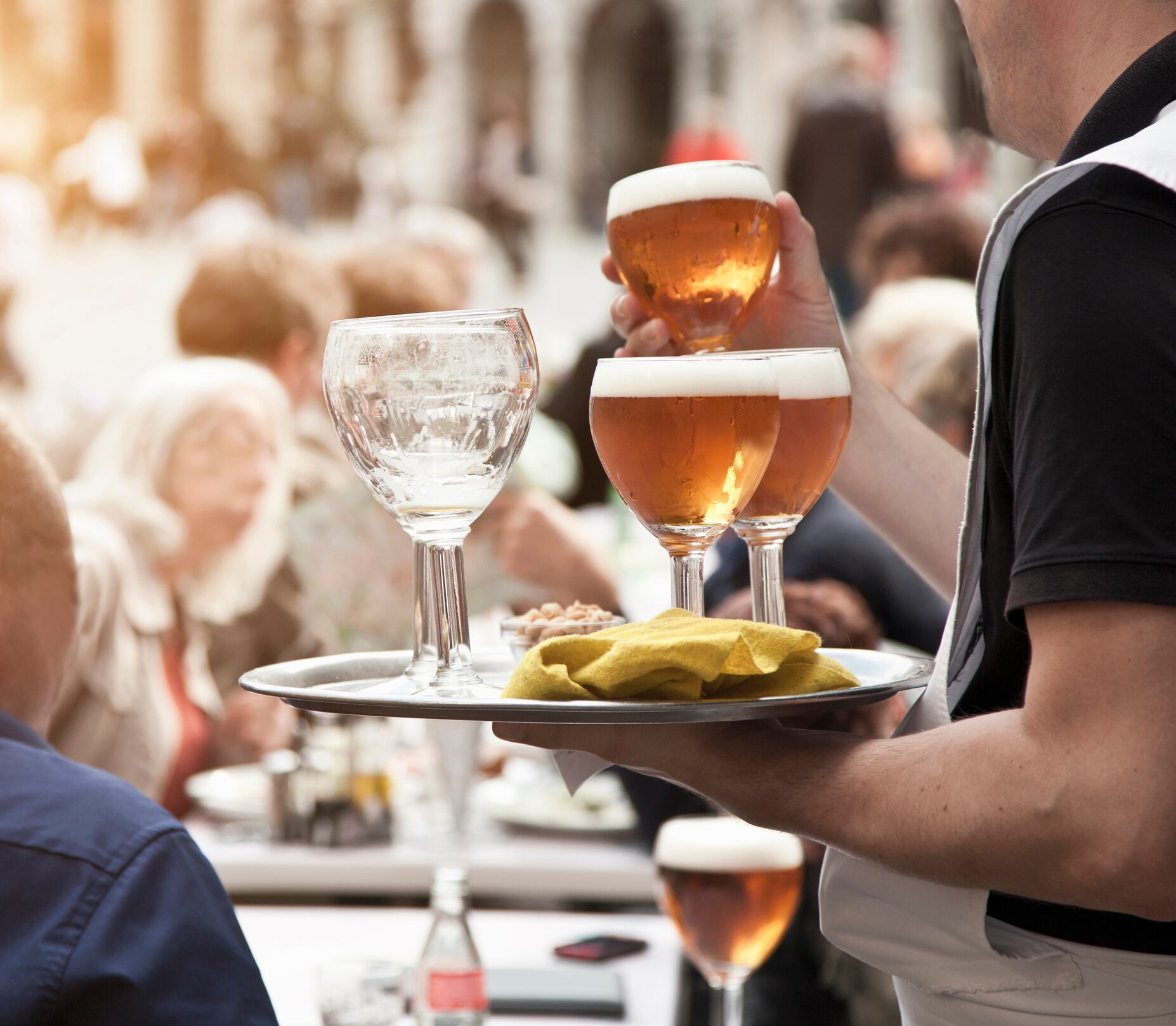 Camarero sirviendo cervezas en una terraza