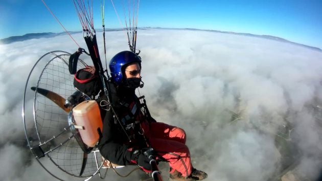 En vuelo en paramotor sobre un paisaje de nubes