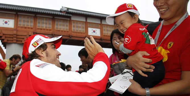 Alonso saluda a un niño antes de la sesión de clasificación