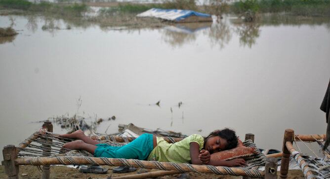 Una niña desplazada duerme fuera de su tienda después de las fuertes lluvias producidas en la India