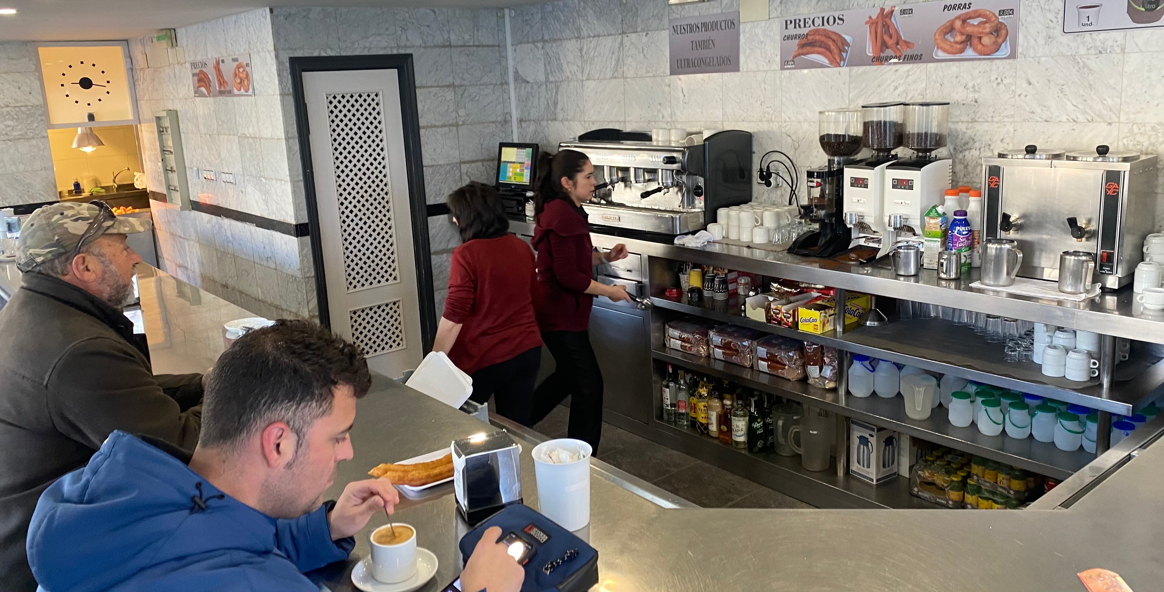 Decenas de conquenses y visitantes desayunan cada mañana en la churrería de la plaza de España de Cuenca.