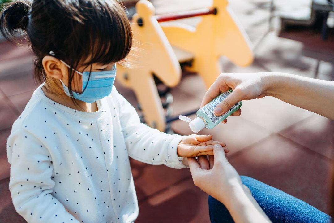 Niña con mascarilla y gel hidroalcohólico 