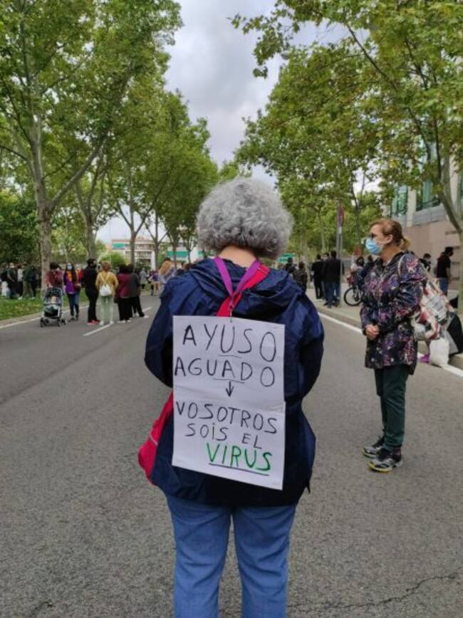 Una vecina con un cartel a la espalda.