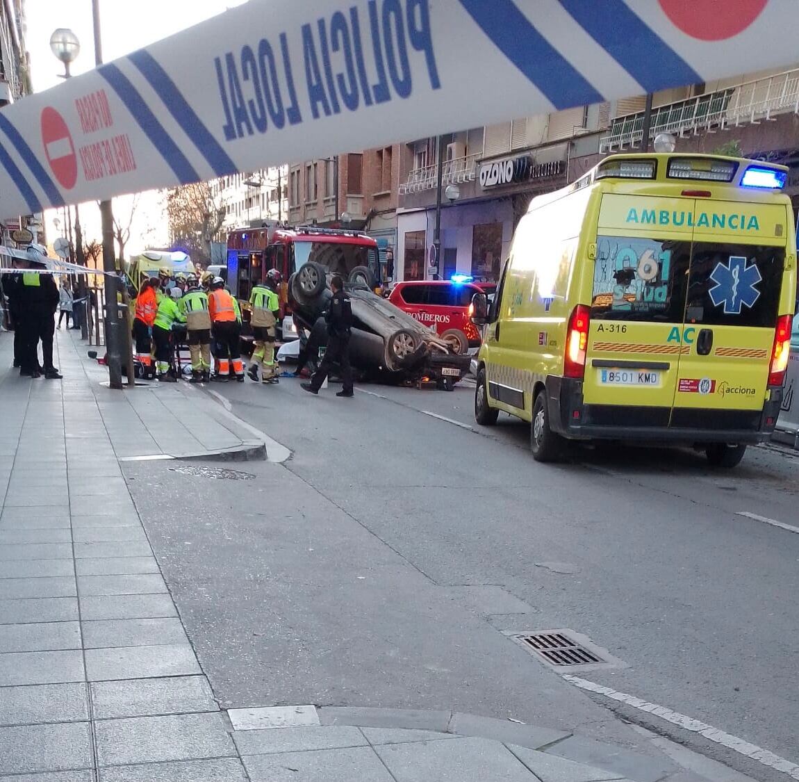 Estado en el que ha quedado el coche, volcado en medio de la calle, tras el choque