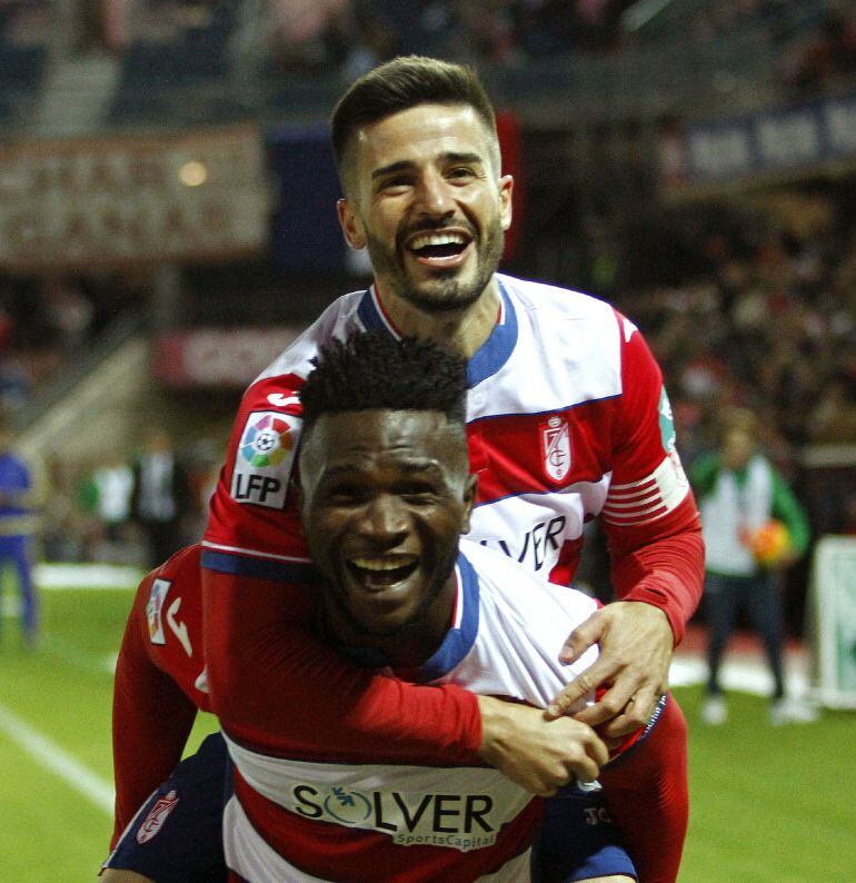 Los jugadores del Granada, el nigeriano Isaac Success (abajo) y Fran Rico, celebran el primer gol del equipo, durante el partido de la duodécima jornada de liga en Primera División que Granada y Athletic Club disputan esta noche en el estadio Nuevo Los Cármenes