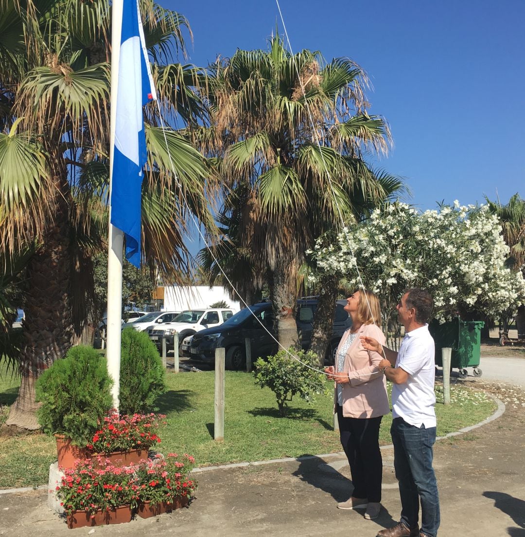 El concejal de turismo, Jose Lemos, y la alcaldesa de Motril, Luisa García Chamorro, izan la bandera Azul en Playa Granada