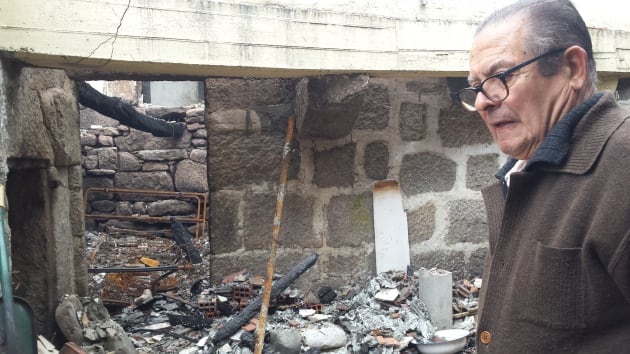 José Serrano muestra su casa quemada en la aldea de Saa, de Carballeda de Avia, Ourense