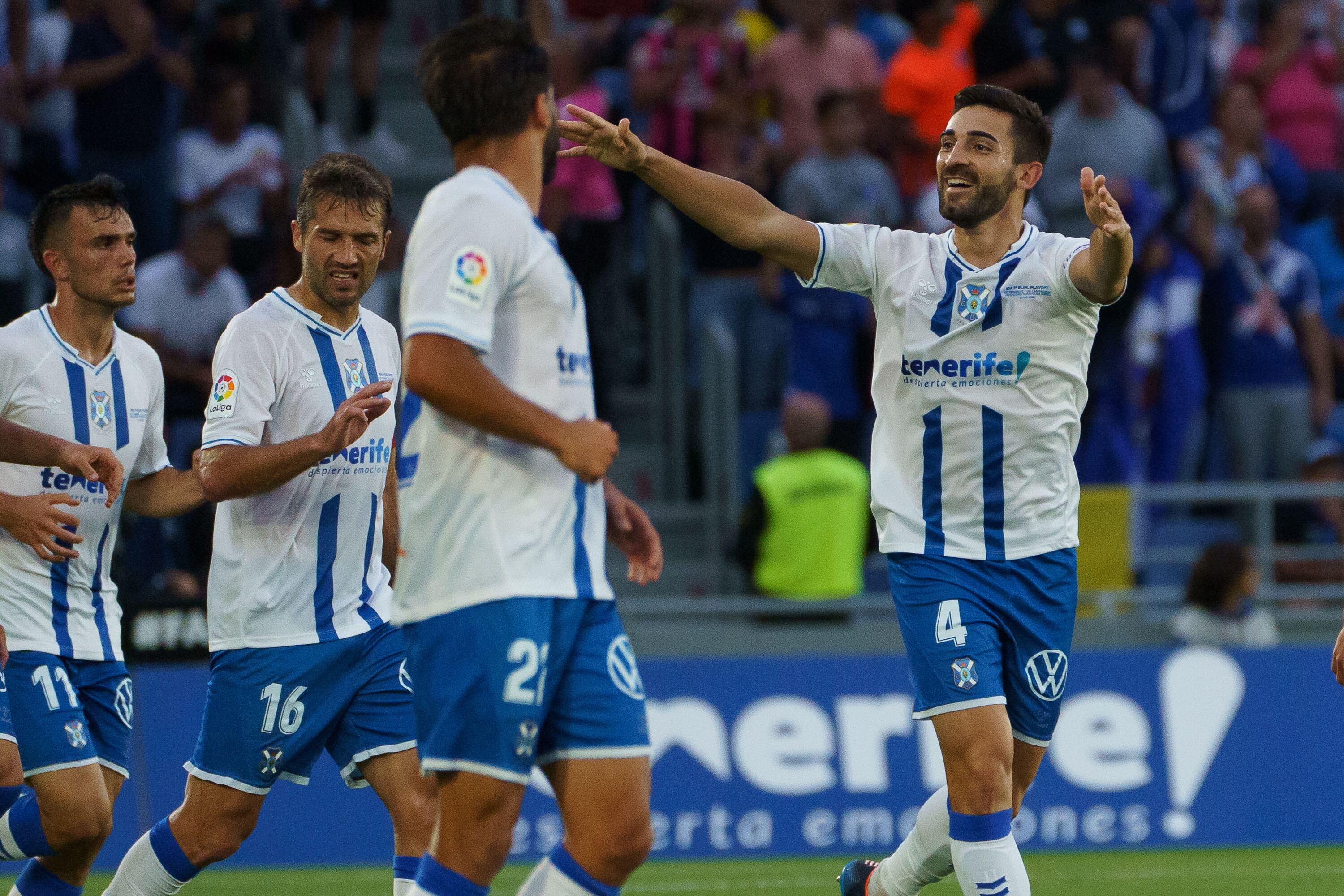 SANTA CRUZ DE TENERIFE, 01/06/2022.- El defensa del CD Tenerife José León (d) celebra con sus compañeros tras marcar ante la UD Las Palmas, durante el partido de la primera eliminatoria del playoff de ascenso a Primera División que se disputa este miércoles en el estadio Heliodoro Rodríguez López. EFE/Ramón de la Rocha
