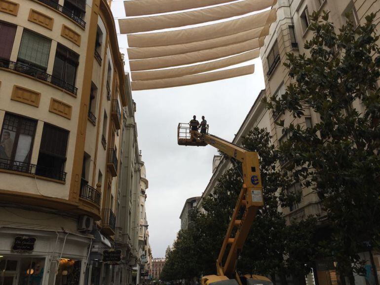 Operarios instalan los primeros toldos en la calle Cruz Conde