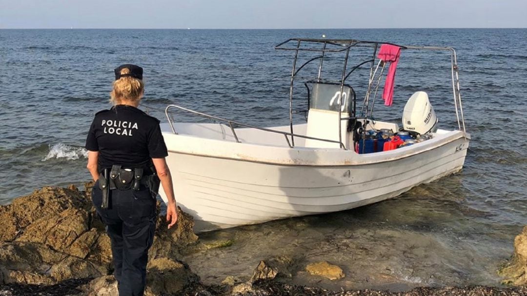 Una agente inspecciona la embarcación en la que llegaron al Carabassi