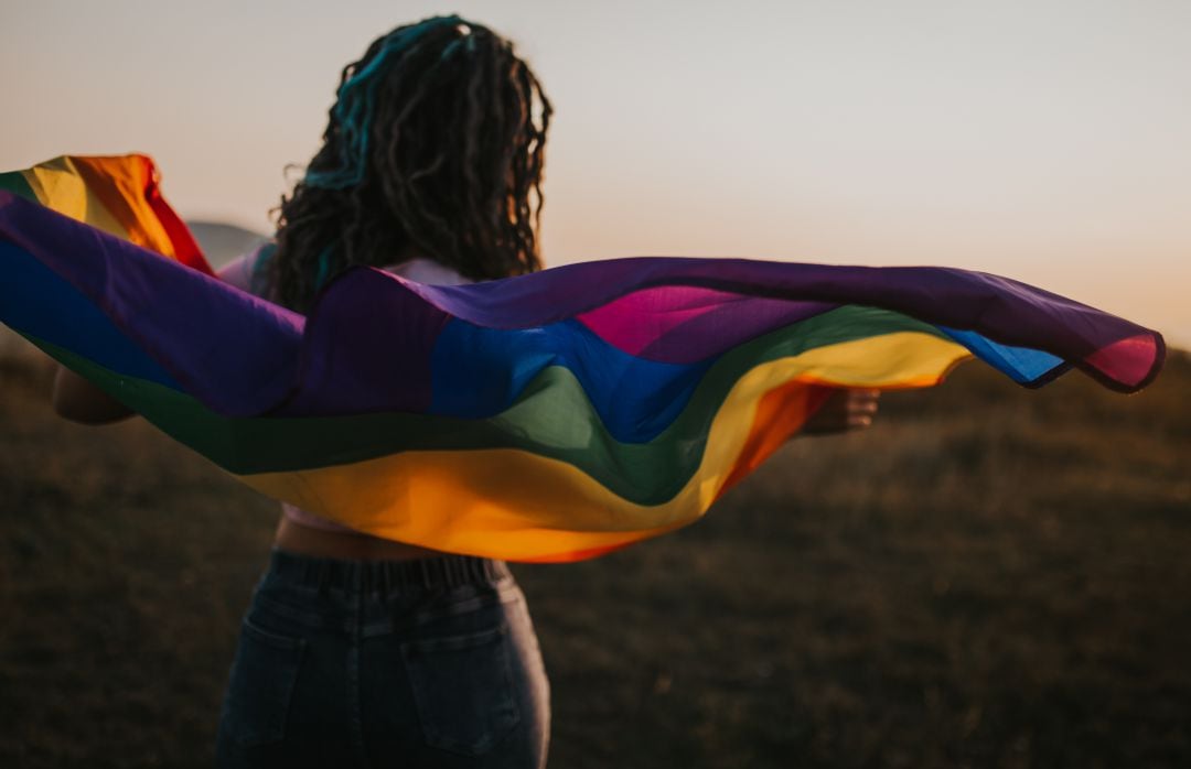 Chica con la bandera de la comunidad LGTBIQ+.