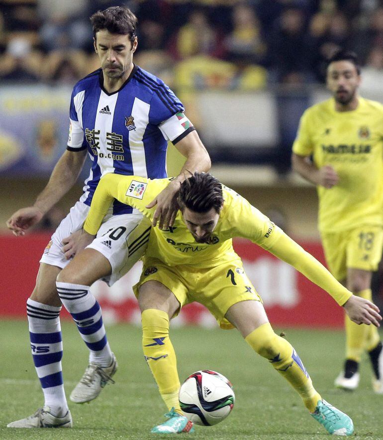 GRA243. VILLARREAL (CASTELLÓN), 07/01/2015.- El centrocampista de la Real Sociedad Xabi Prieto (i) pelea un balón con el centrocampista del Villarreal Moi Gómez en el partido de ida de los octavos de final de la Copa del Rey que se disputa esta tarde en el estadio del Madrigal.EFE/Domenech Castelló