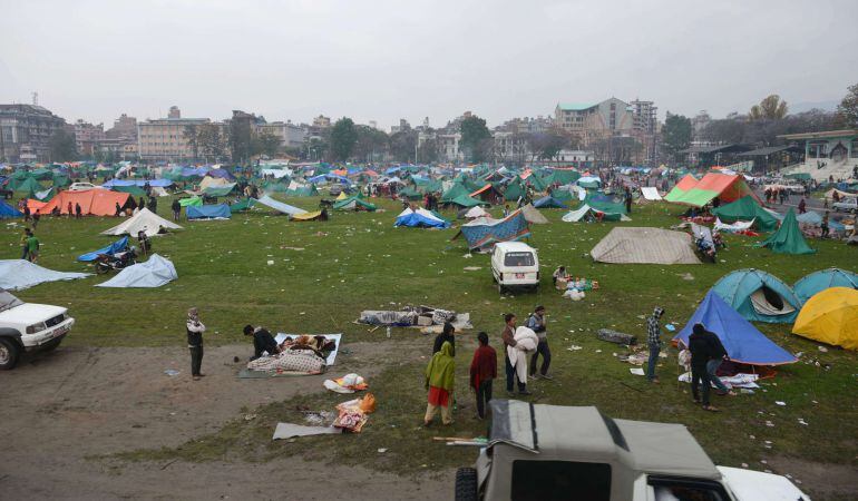 Nepalese people gather near temporary shelters set up in open areas of an Army ground in Kathmandu on April 27, 2015, two days after a 7.8 magnitude earthquake hit Nepal. International aid groups and governments intensified efforts to get rescuers and sup