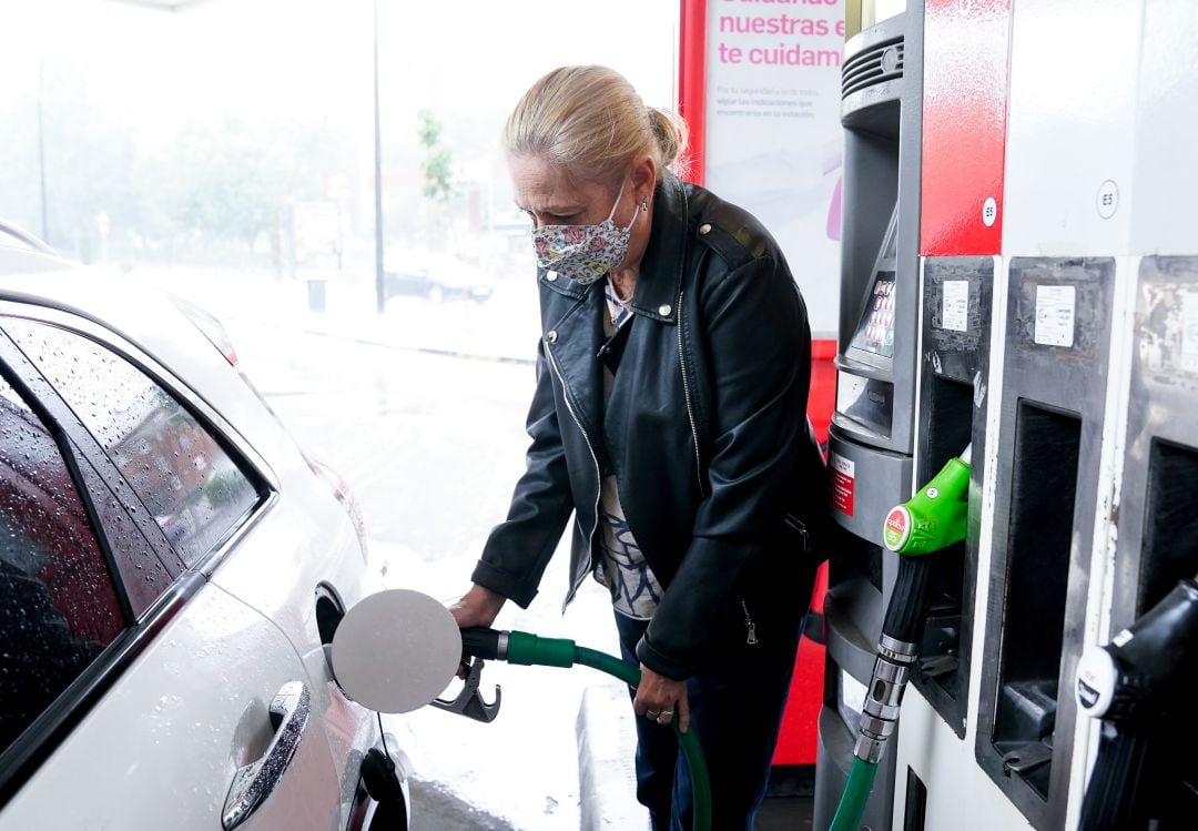 Una mujer echa gasolina a su coche.