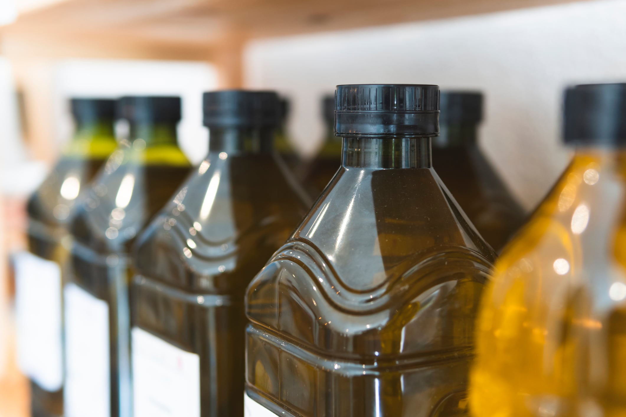 Botellas de aceite de oliva dispuestas para su compra en un estante de supermercado.