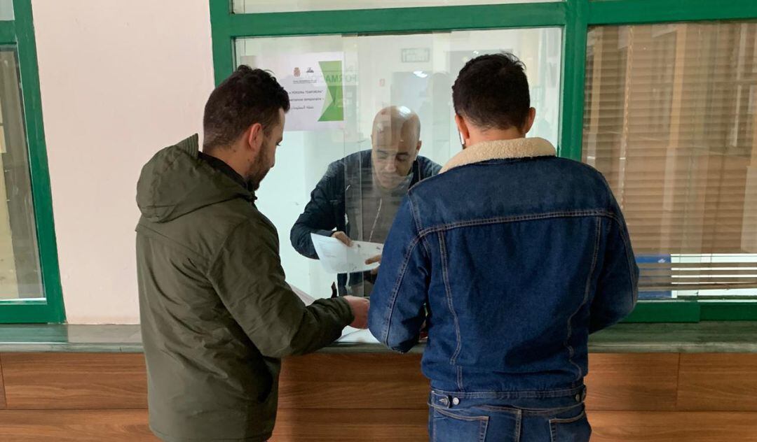 Dos hombres acuden al punto de información para temporeros puesto en marcha en la Estación de Autobuses de Jaén capital.