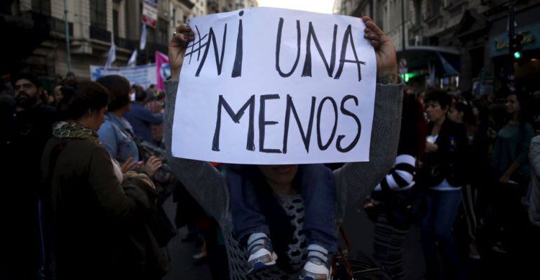 Una mujer lleva una pancarta en contra de la violencia de género durante una manifestación.