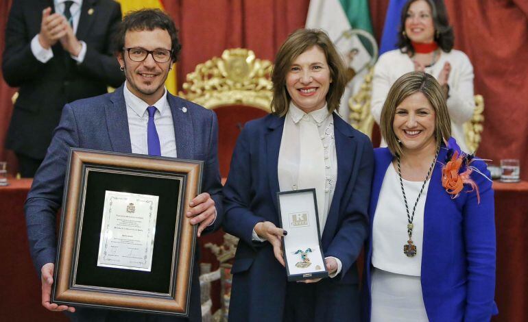 Momento en el que la directora de Radio Cádiz, Lourdes Acosta, recibe la medalla de manos de José María González e Irene García