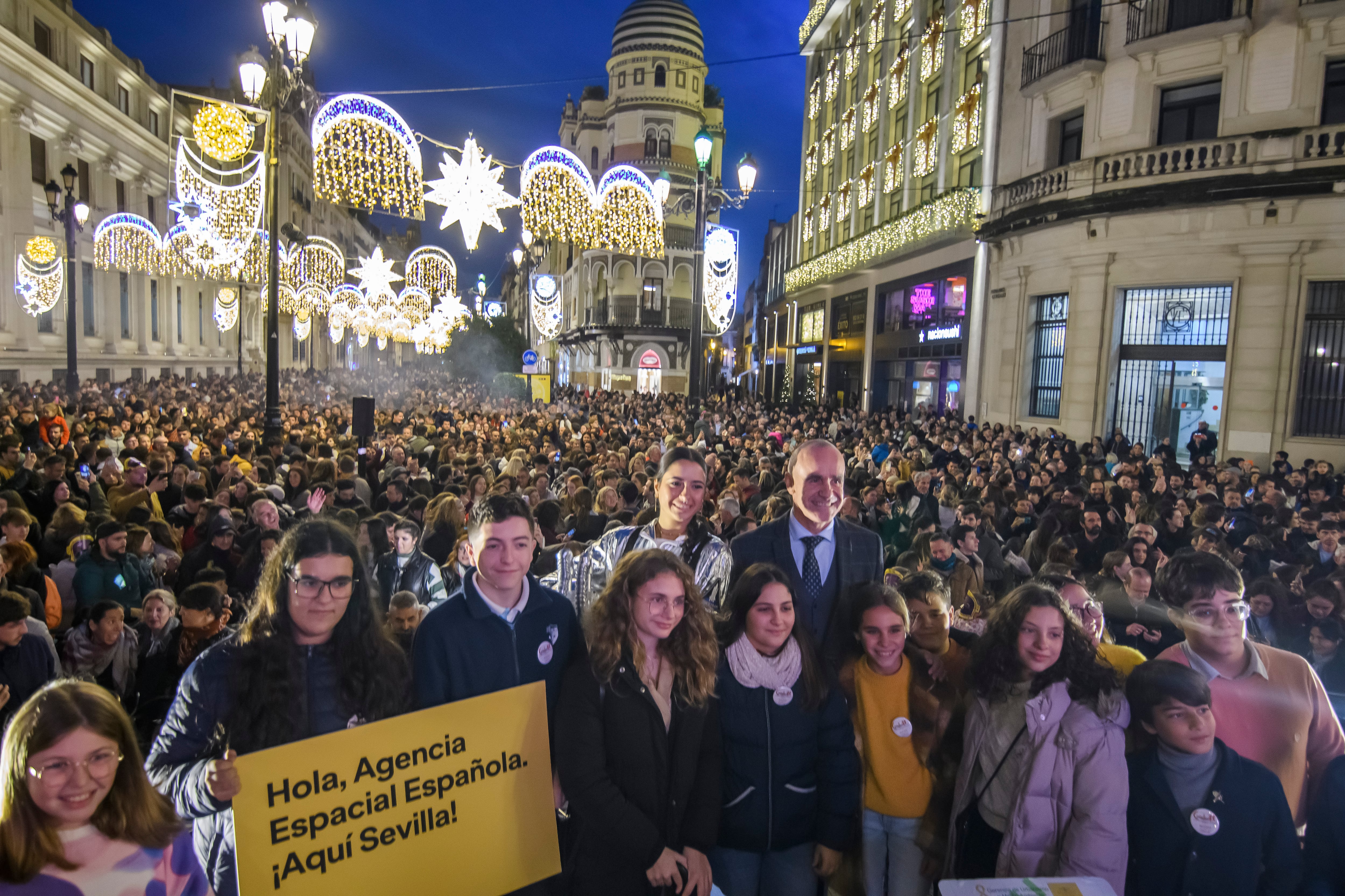 El alcalde de Sevilla, Antonio Muñoz (d), celebra la asignación de la ciudad como sede de la futura Agencia Espacial Española (AEE) durante el acto de inauguración del alumbrado navideño.