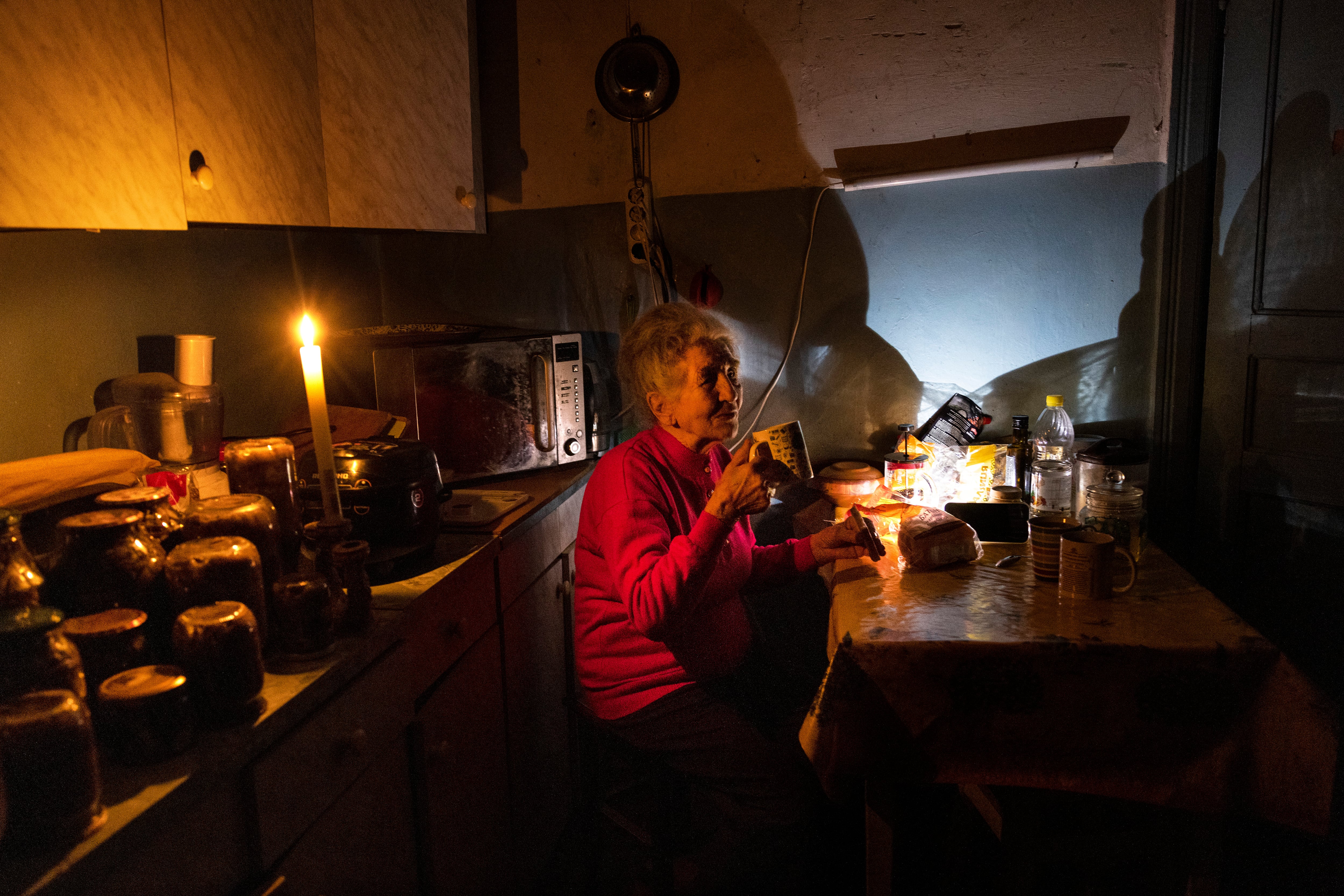 Natalia Zemko, de 81 años, bebe té en la cocina de su casa durante un apagón en la ciudad de Kiev.