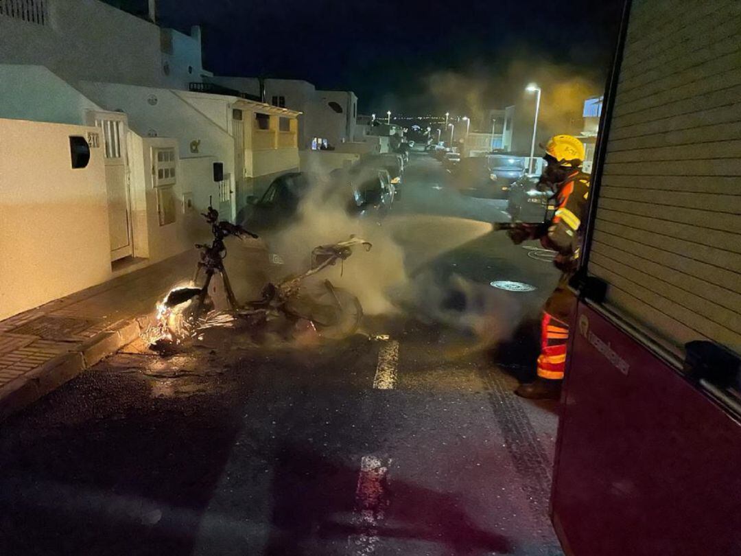 Los bomberos extinguiendo el incendio de la motocicleta.