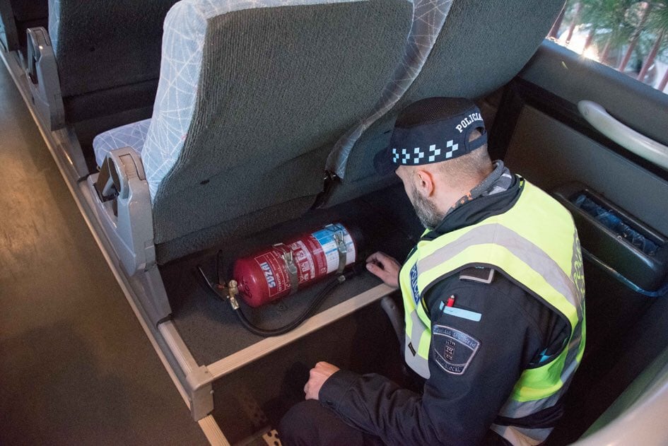 Agente revisando el interior de un autobús escolar