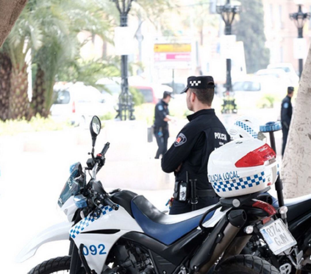 Un agente de servicio al lado de su moto