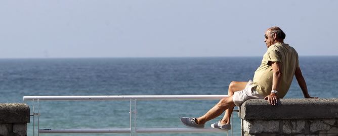 Dos personas disfrutan de una soleada tarde en la playa de la Zurriola de San Sebastián