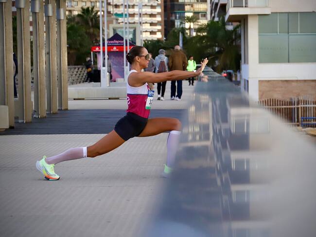 Una corredora estira antes de la salida de la carrera