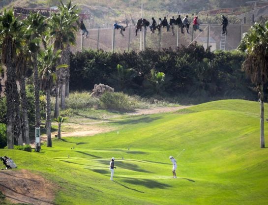 Al menos doce inmigrantes, encaramados en la valla de Melilla frente al campo de golf situado al lado de la alambrada que separa la ciudad autonoma de Marruecos/ Fotografia Jose Palazon / Pro.de.in